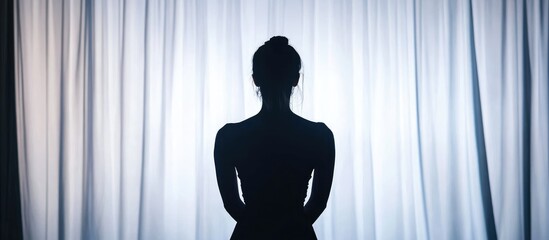 Silhouette of a young actress against a studio backdrop with soft lighting and ample space for promotional text or messaging