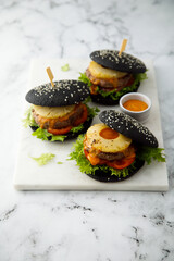 Black burgers with grilled pineapple