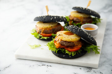 Black burgers with grilled pineapple