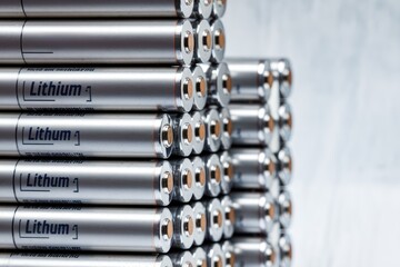 Lithium batteries forming a stack on grey background