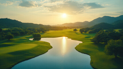 Fototapeta premium stunning green golf field with serene lake reflects sunset, surrounded by lush trees and mountains. tranquil atmosphere invites relaxation and enjoyment