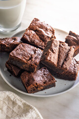 Homemade chocolate brownies on plate on kitchen table.