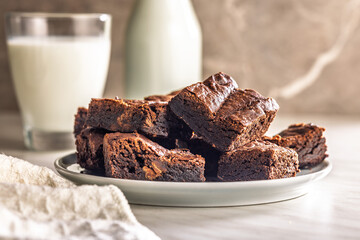 Homemade chocolate brownies on plate on kitchen table.