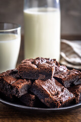 Homemade chocolate brownies on plate on wooden table.