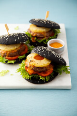 Black burgers with grilled pineapple