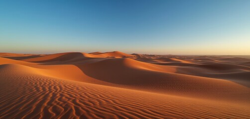 Naklejka premium Golden sand dunes under a clear twilight sky