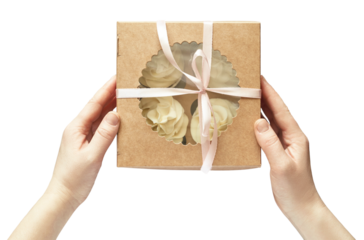 Caucasian female hands holding brown box with white cupcakes tied with pink 