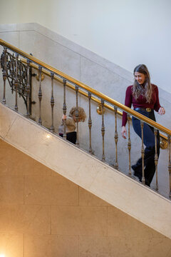 Woman and child descending a grand staircase with ornate railing in an elegant building. Cleveland, Ohio, USA