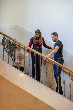 A family navigates a staircase, with a young child leading the way and parents following behind. Cleveland, Ohio, USA