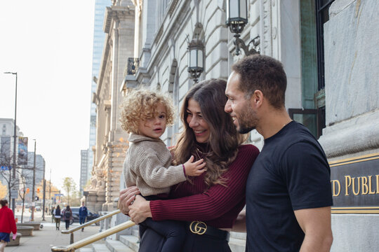 Family of three enjoying time together outside a public building Cleveland, Public Library, Ohio, USA
