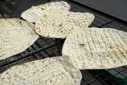 Freshly baked traditional Iranian flatbread cooling on a wire mesh, Teheran, Iran