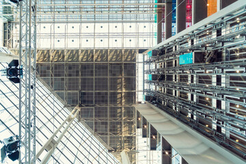 Interior view of a modern building featuring a vast atrium with a glass ceiling, structural steel beams, and multiple levels, Helsinki, Finland