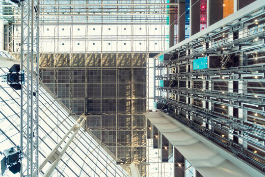 Interior view of a modern building featuring a vast atrium with a glass ceiling, structural steel beams, and multiple levels, Helsinki, Finland