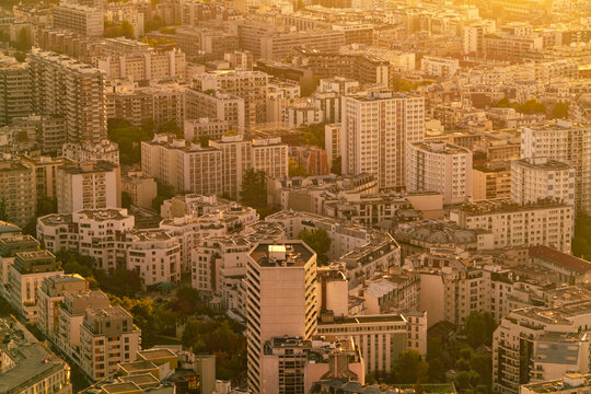Aerial view of a densely populated urban area in Paris with skyscrapers and residential buildings basked in golden sunlight, Paris, France