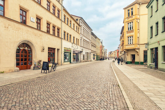 Cobblestone street in the old city of Luther City of Wittenberg with historical buildings and pedestrians, Lutherstadt Wittenberg