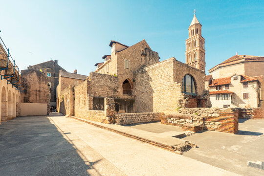 Sunlit view of an old stone church with a bell tower of St Domnius, situated in a cobblestone street of a historic Split, Croatia.