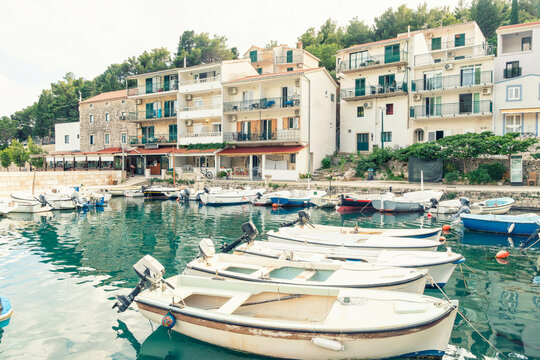 Coastal town of Drvenik with moored boats in the foreground and multistory buildings in the background, , Drvenik, Croatia.