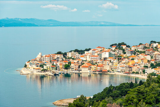 Coastal town of Igrane nestled on a hillside with terracotta roofs overlooking a calm blue sea under a clear sky, Igrane, Croatia