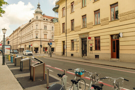Sunny city street featuring a bicycle lane, rental bikes, and historical architecture, Ljubljana, Slovenia