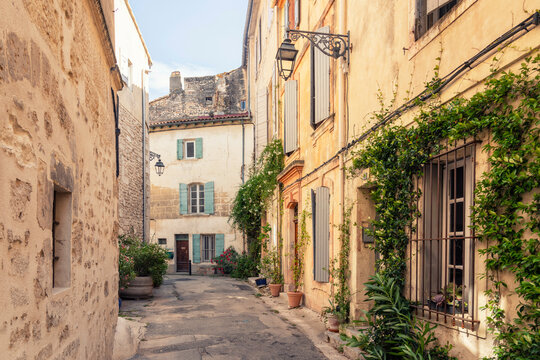 Fototapeta Narrow street with colorful shutters and historic buildings in Arles, France