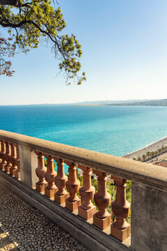 Scenic view of a turquoise sea from a stone balcony with terracotta balustrades under a clear blue sky, Nice, France