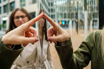A woman is touching a glass surface while another woman watches, Berlin, Germany