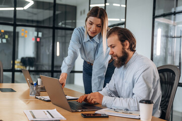 Successful, smiling and working. Man and woman are in the office together
