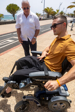 Two men enjoying a day outdoors, one using a wheelchair