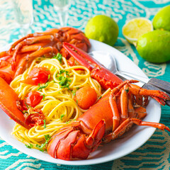 Lobster linguine pasta served with tomatoes and fresh lemons. Delicatessen, rare seafood pasta recipe. Sardinia, Sicilian, Neapolitan cuisine. Italian and French, Nord America  recipe. Square crop
