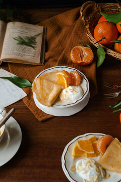 Rustic breakfast setting with citric crepes and yogurt