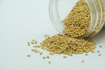 Sesame Seeds falling from glass jar, sesame seeds