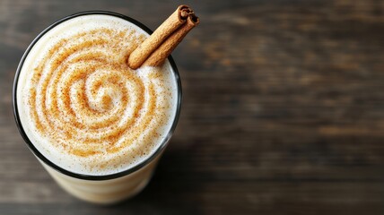 Fototapeta premium Creamy Cinnamon Spiced Smoothie in Glass Top View Wooden Background