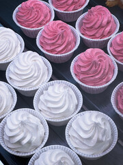 cupcakes decorated with white and pink protein cream. 