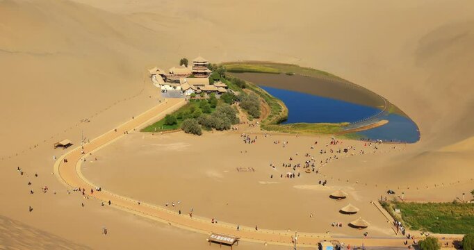 Time lapse of Dunhuang Crescent Spring and Singing Sand Mountain.Dunhuang Crescent Spring is located in the ring of the sand Mountain, because the shape of a curved crescent moon named.