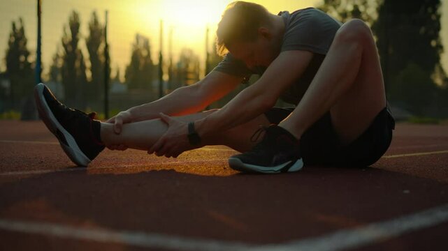Fitness. Sportsman in sportswear working hard to improve his physical fitness on the sports ground. Cinematic shot of a sporty man preparing for a competition keeping fit, stadium