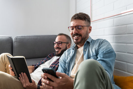 Happy gay couple enjoying leisure time together at home