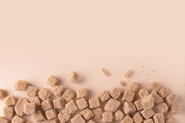 pieces of brown sugar on a beige background, copy space