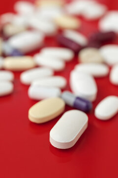 Assorted medical tablets on a vivid red background