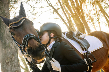 Teenager in classical dressage attire bonding with horse