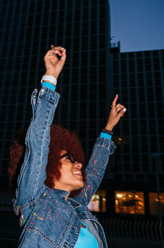 Joyful African descendant woman celebrating outdoors at night