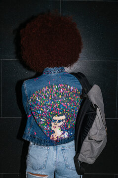 Back view of unrecognizable woman with decorative denim jacket