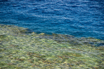 Transparent turquoise water of Red Sea on beach of Naama Bay hotel. Close-up. Sea is completely calm. Atmosphere of calm and relaxation.