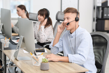 Salesman talking to client via headset at desk in office
