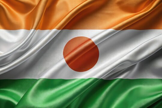 A patriotic Niger Independence Day image: the flag billows, celebrating freedom on a stark white background. - Powered by Adobe