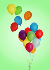 Many colorful balloons in air on light green background. Birthday or other party decoration