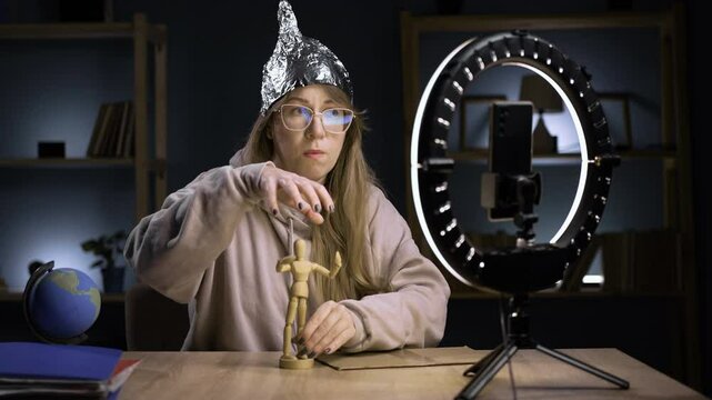 Strange crazy blogger with cellphone, paranoid woman streaming at home conspiracy theory broadcasting in vlog, telling total control and people. blogging and technology