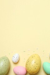 Colorful eggs, sweet sprinkles on pastel beige backdrop, space for your text or advertisement