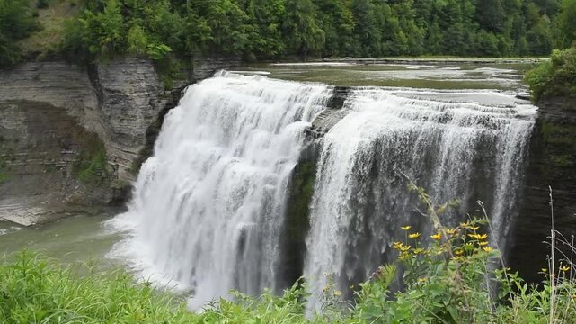 A waterfall is flowing with fresh water cascading down into a stream for a nature travel concept.