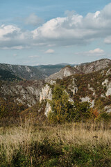 Obraz premium Steep cliffs and an autumn forest on a sunny, warm day. Rocky mountain landscape. Beautiful nature of southwestern Serbia.