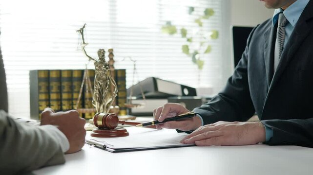 Close up of hands Lawyers explain and discuss matters of law then shakehands after and dealing contract agreement to clients discuss for prepare for the trial. gavel hammer and scales of justice.